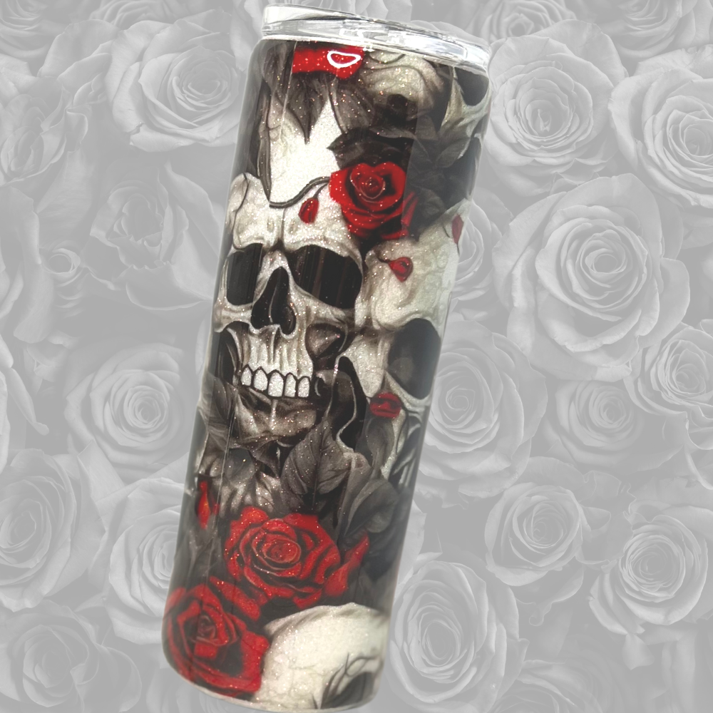 20oz tumbler, showing one side of the tumbler to reveil the images around the cup.  Multiple skulls stacked over the other, surround by red and black roses.  The back is white glitter so it's visible through the white skulls.