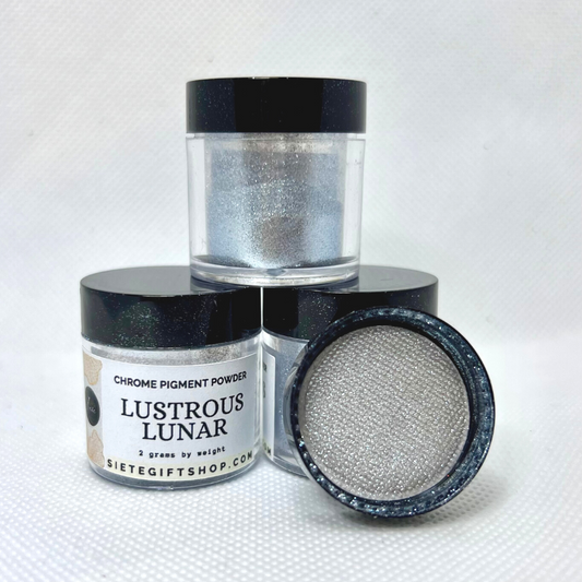 Three clear containers with black lids, each filled with 2 grams of silver pigments. One lids is showing the inside of the lid to display the shiny silver powders. 