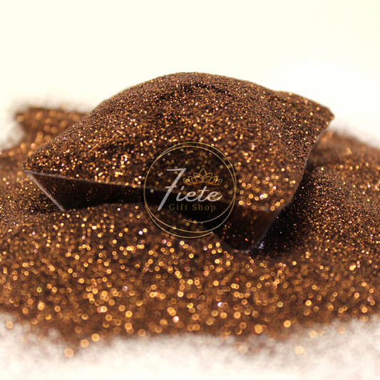 A heap of sparkling, extra-fine metallic brown glitter with a rich, coppery tone similar to an old penny, showcased on a subtle gradient background with a logo of "Siete Gift Shop" in the center.